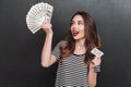 Happy young lady holding money and debit card in hands Royalty Free Stock Photo