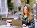 Happy young lady in stylish outfit smiling and enjoying hot beverage Royalty Free Stock Photo