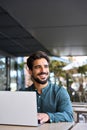 Happy young Latin business man using laptop working outdoors, portrait. Royalty Free Stock Photo