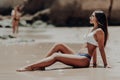 Happy young latin woman in bikini sitting on beach enjoy the summer vocation. Royalty Free Stock Photo