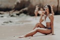 Happy young latin woman in bikini sitting on beach enjoy the summer vocation. Royalty Free Stock Photo