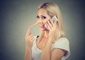 Happy young liar woman with long nose talking on mobile phone