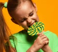 Happy young little child girl kid bite sweet lollypop candy Royalty Free Stock Photo