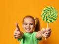 Happy young little child girl with sweet lollypop candy surprised screaming yelling Royalty Free Stock Photo