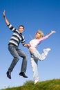 Happy Young love Couple - jumping under blue sky Royalty Free Stock Photo