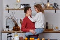 Happy young lovely couple on kitchen hugging each other. They enjoy spending time togehter Royalty Free Stock Photo