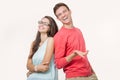 Happy young lovely couple standing back to back and smiling looking at camera on white background Royalty Free Stock Photo