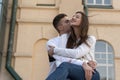 Happy young loving couple hugging in the background of urban architecture. Guy kissing his girlfriend Royalty Free Stock Photo