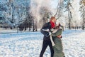 Happy young couple playing with snow in winter park. Man and woman having fun outdoors. Royalty Free Stock Photo