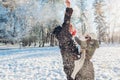 Happy young couple playing with snow in winter park. Man and woman having fun outdoors. Royalty Free Stock Photo