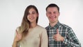 Happy young loving couple smiling to the camera, showing thumbs up Royalty Free Stock Photo