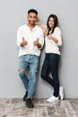 Happy young loving couple standing over grey wall Royalty Free Stock Photo