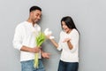 Happy young loving couple standing over grey wall Royalty Free Stock Photo