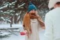 Happy young loving couple walking in snowy winter forest, covered with snow Royalty Free Stock Photo