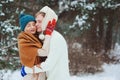 Happy young loving couple walking in snowy winter forest, covered with snow Royalty Free Stock Photo