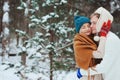 Happy young loving couple walking in snowy winter forest, covered with snow Royalty Free Stock Photo