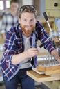 Happy young male carpenter working wood plank at workshop Royalty Free Stock Photo