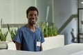 Happy young male clinician or assistant in blue medical uniform