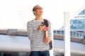 Happy young male college student walking on campus with smart phone Royalty Free Stock Photo