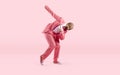 Funny young male dancer in pink suit and glasses dancing against pink studio background Royalty Free Stock Photo