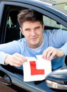 Happy young male driver tearing up his L sign Royalty Free Stock Photo