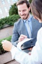 Happy young male and female business people talking in front of an office building, having a meeting and discussing Royalty Free Stock Photo