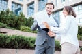 Happy young male and female business people talking in front of an office building, having a meeting and discussing Royalty Free Stock Photo