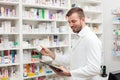 Happy young male pharmacist working in the pharmacy Royalty Free Stock Photo