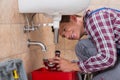 Plumber Installing Sink Pipe In Bathroom