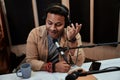 Happy young male radio host talking, broadcasting in studio using microphone and headphones Royalty Free Stock Photo