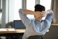 Happy young male worker employee resting on chair during workday. Royalty Free Stock Photo