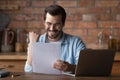 Happy young man analyst reading marketing report raising hand super Royalty Free Stock Photo