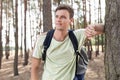Happy young man with backpack hiking in woods Royalty Free Stock Photo