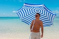 Happy young man with beach umbrella on the beach. Summer vacation concept Royalty Free Stock Photo