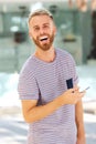 Happy young man with beard holding cellphone Royalty Free Stock Photo