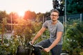 Happy young man with bicycle in park. With glasses for sight at sunset.