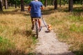 Man on bike in park in the company of his dog. Royalty Free Stock Photo