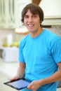 Happy young man in blue T-shirt with tablet Royalty Free Stock Photo