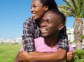 Happy young man carrying girlfriend on back