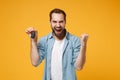 Happy young man in casual blue shirt posing isolated on yellow orange background, studio portrait. People emotions Royalty Free Stock Photo