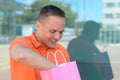 Happy young man delving in a shopping bag