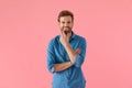 Happy young man in denim shirt smiling and touching chin Royalty Free Stock Photo