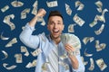 Happy young man with dollars under money rain on background Royalty Free Stock Photo