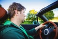 Happy young man driving a cabriolet car on sunny summer day. Sunset, happiness, freedom Royalty Free Stock Photo