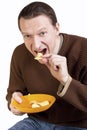 Happy young man eating potato chips Royalty Free Stock Photo