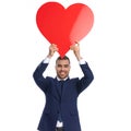 happy young man in elegant suit holding heart above head Royalty Free Stock Photo