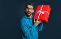 Happy young man in eyeglasses holding gift box with ribbon Royalty Free Stock Photo