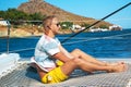 Happy young man feels happy on the luxury sail boat yacht catamaran in turquoise sea in summer holidays on island. Royalty Free Stock Photo