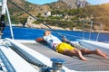 Happy young man feels happy on the luxury sail boat yacht catamaran in turquoise sea in summer holidays on island. Royalty Free Stock Photo