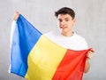 Happy young man holding flag of Romania against unicoloured background Royalty Free Stock Photo